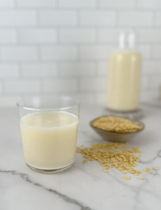 Glass of homemade plant-based pea milk prepared with dried yellow peas and dates